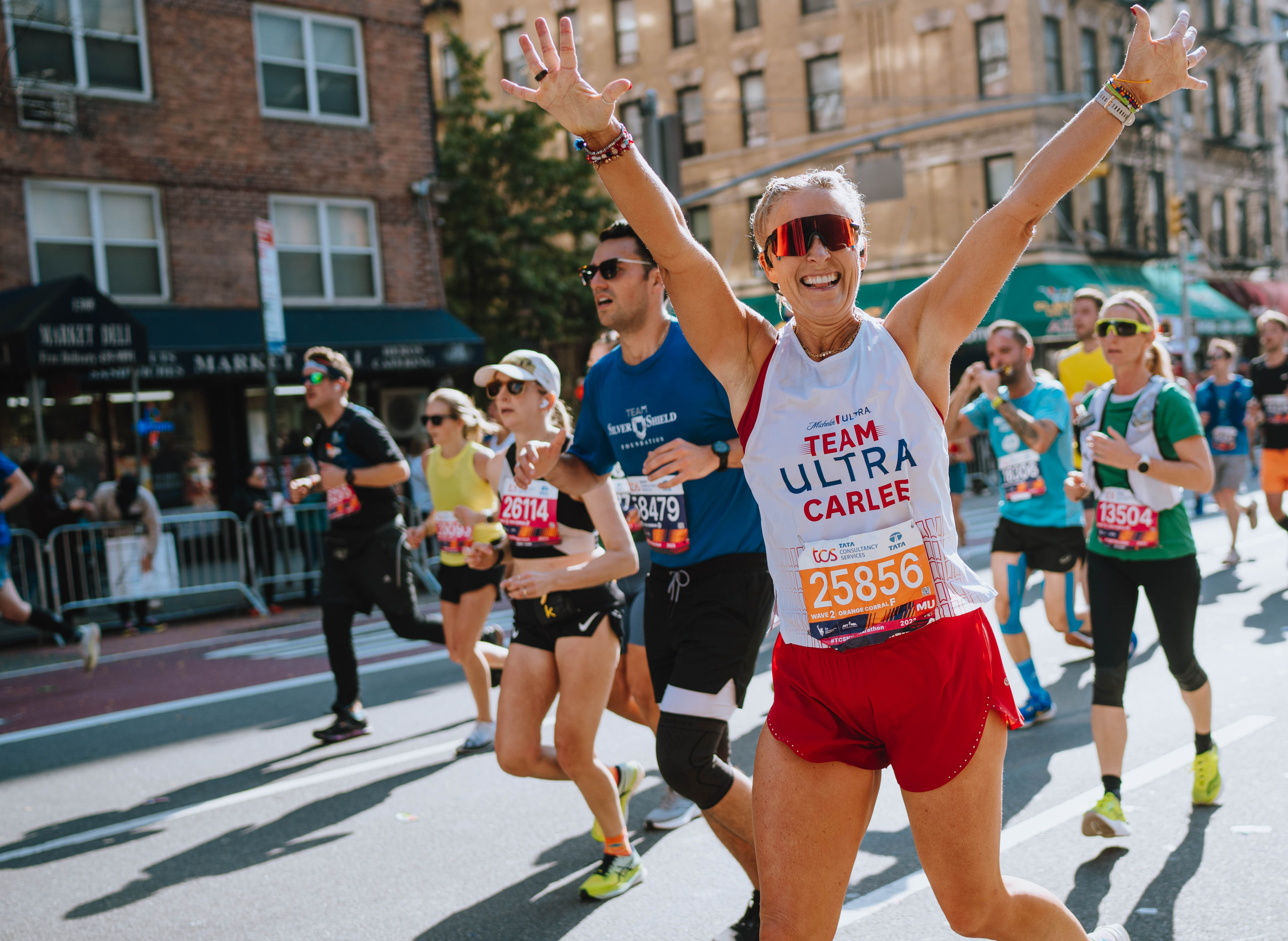 Woman with arms up finishing marathon race