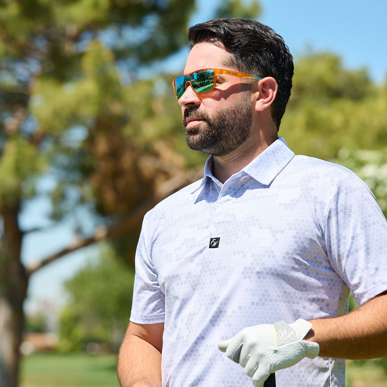 Main wearing orange sunglasses standing on a golf course