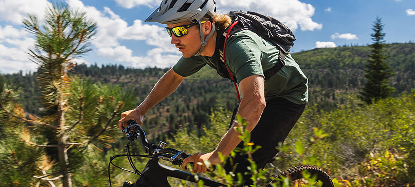 Male mountain biker riding through forest area