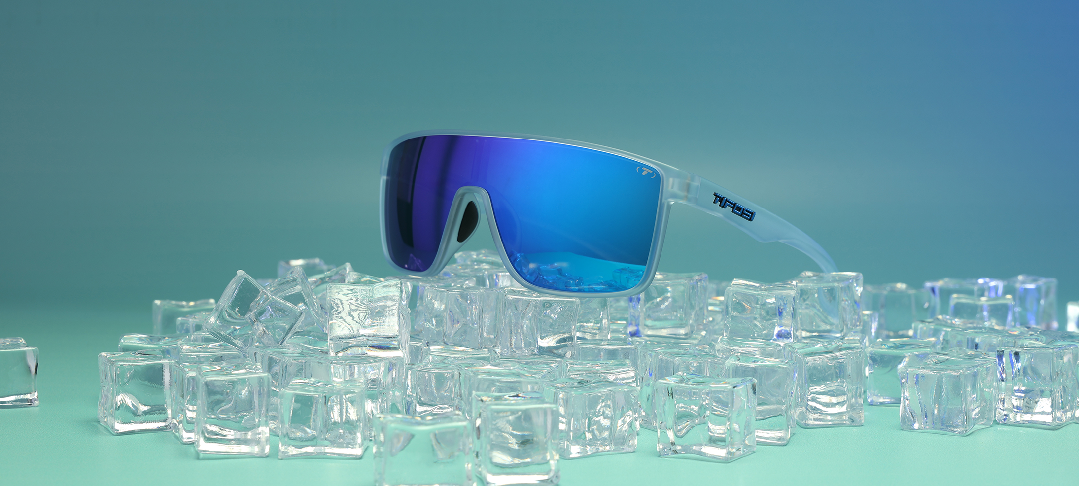 Pair of Sanctum ice blue sunglasses sitting on a pile of ice cubes