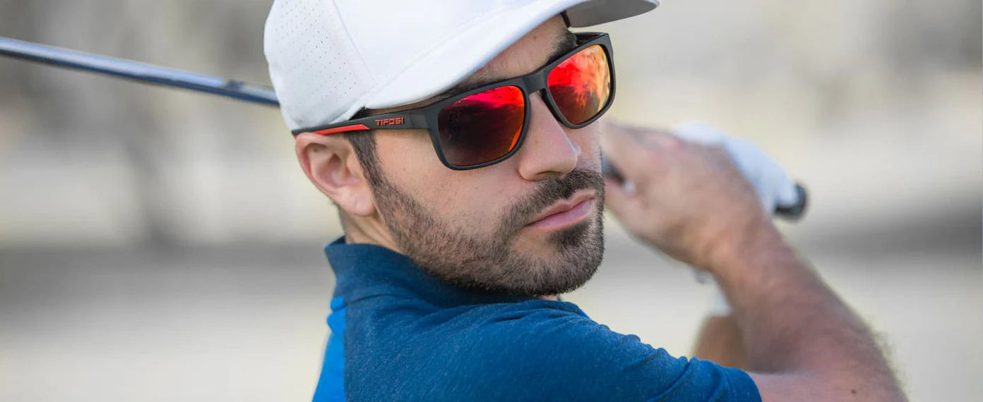 Man swinging golf club wearing Swick sunglasses