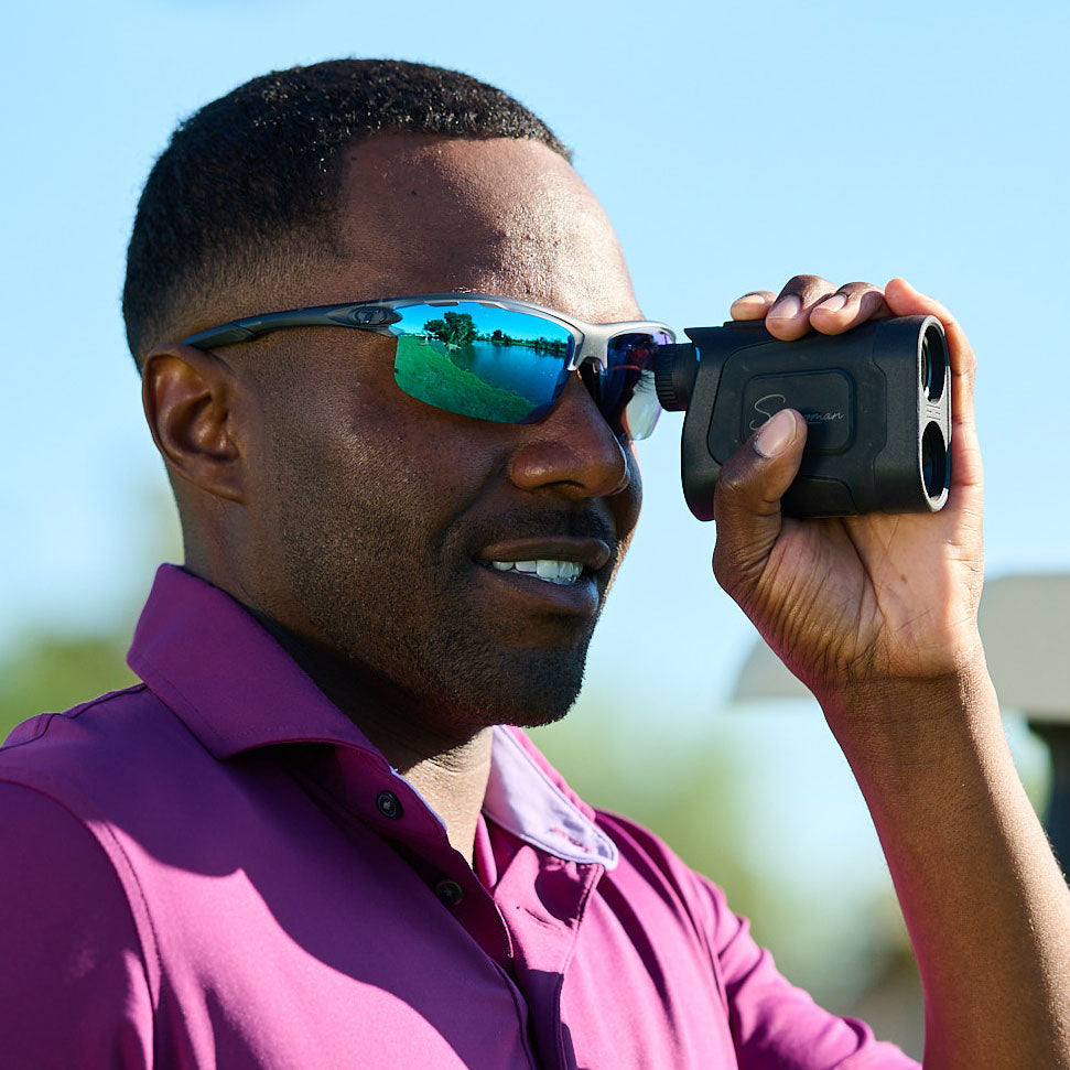Man wearing Tifosi Rivet sunglasses in a purple polo tshirt using a black rangefinder