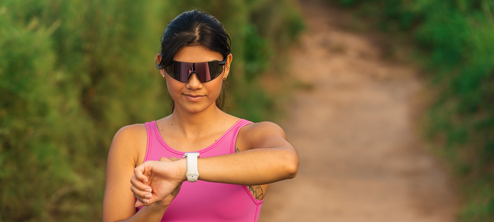 Woman wearing Vogel XC, Matte Black while on a run, checking her watch