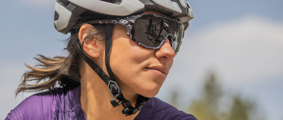 Female cyclist wearing Sledge sport sunglass in moon dust with smoke lens