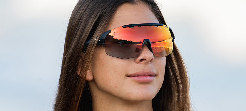 Female wearing Sledge Lite in matte black with clarion red fototec lens