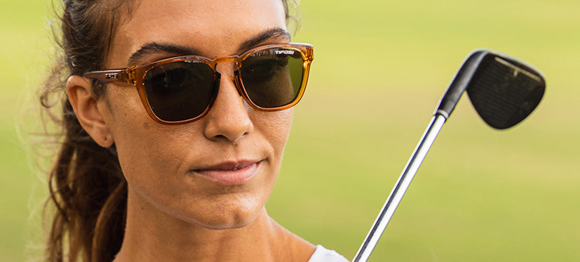 female golfer wearing Smirk sport sunglass in honey color way