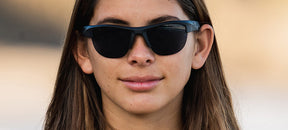 Female wearing Strikeout sport sunglasses in blackout
