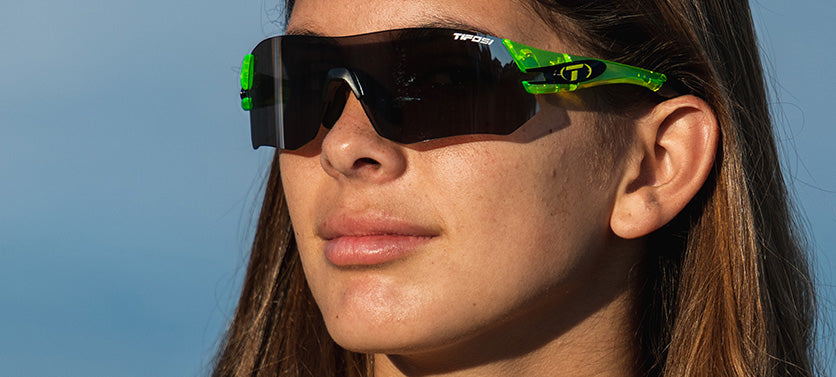 Female wearing Tsali Neon Green sunglasses with Smoke tint lens